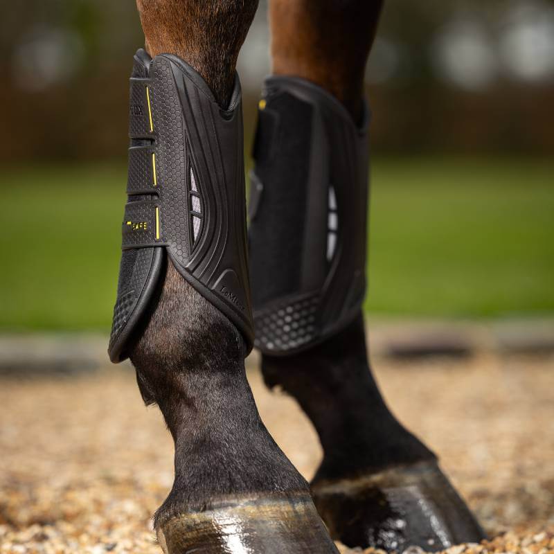 Close-up of a horse’s legs in LeMieux MIMSafe Boot Front Black, standing on gravel.