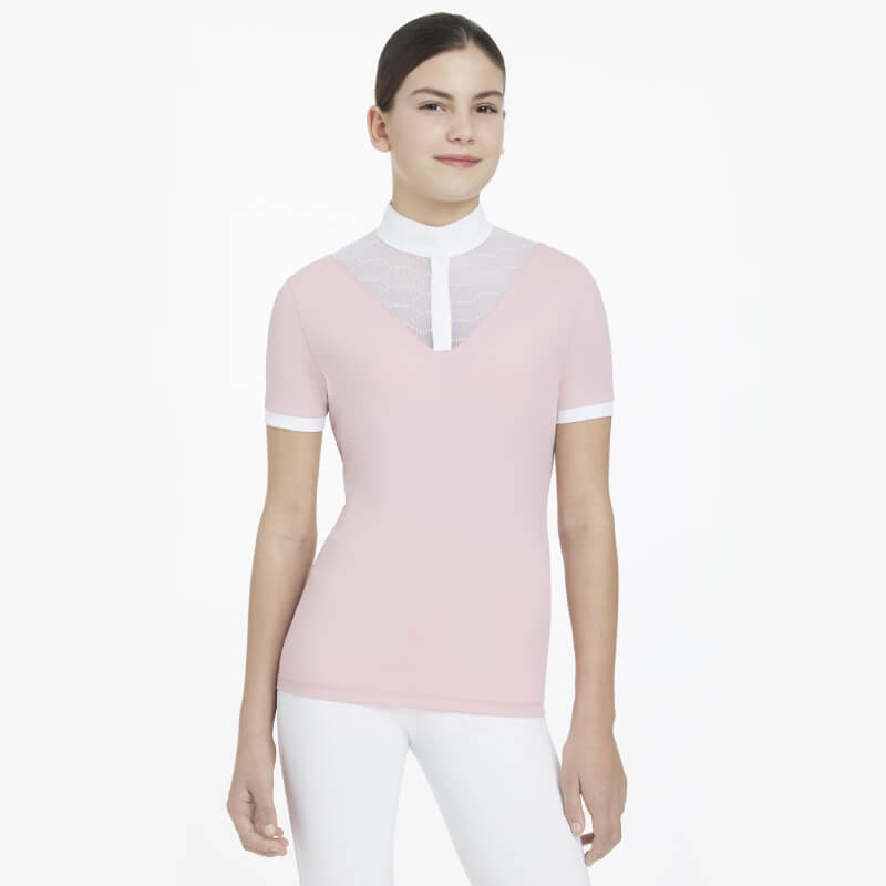 Young woman in a LeMieux Young Rider Eva SS Show Shirt Blossom and white pants, smiling.