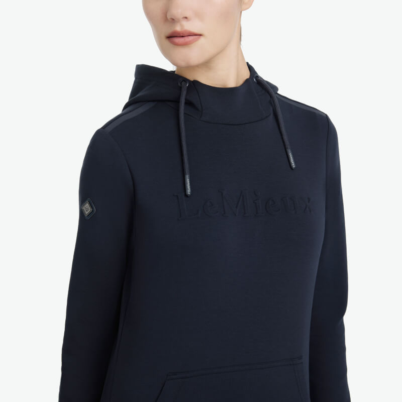 Woman wearing a LeMieux Classique Hoodie Navy with front pocket and drawstring hood.