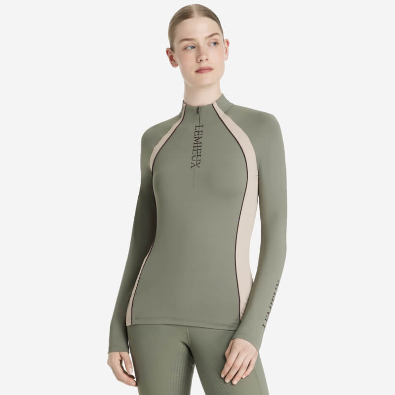 Woman in a fitted LeMieux Phillipa Mesh Baselayer Rosemary and matching pants.