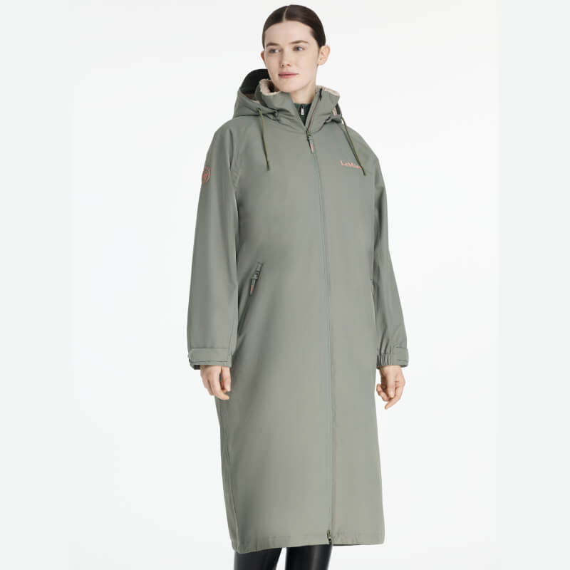 Person in a LeMieux Hydroshield Robe Rosemary with hood, zipper, and pockets, standing upright.