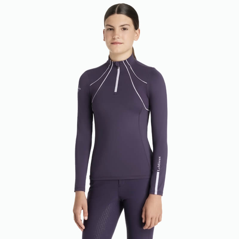 Woman in a LeMieux Young Rider Mia Mesh Baselayer Juniper with long sleeves and zip collar.