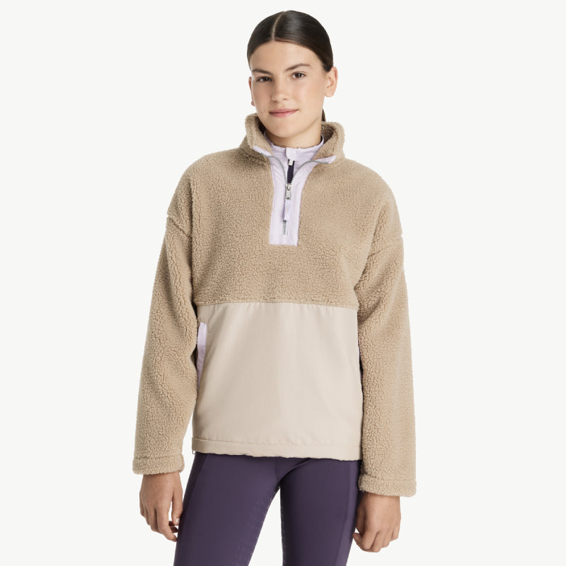 Smiling young woman in LeMieux Young Rider Tammy Teddy Fleece Almond and purple leggings.