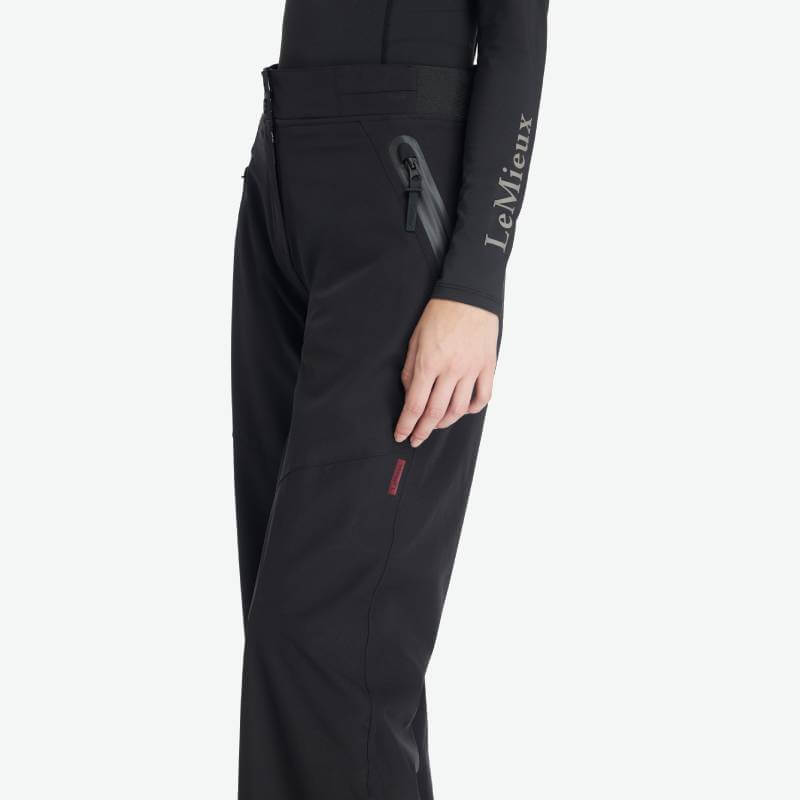 Person in black LeMieux Stormwear Waterproof Trousers and a black LeMieux long-sleeve top.