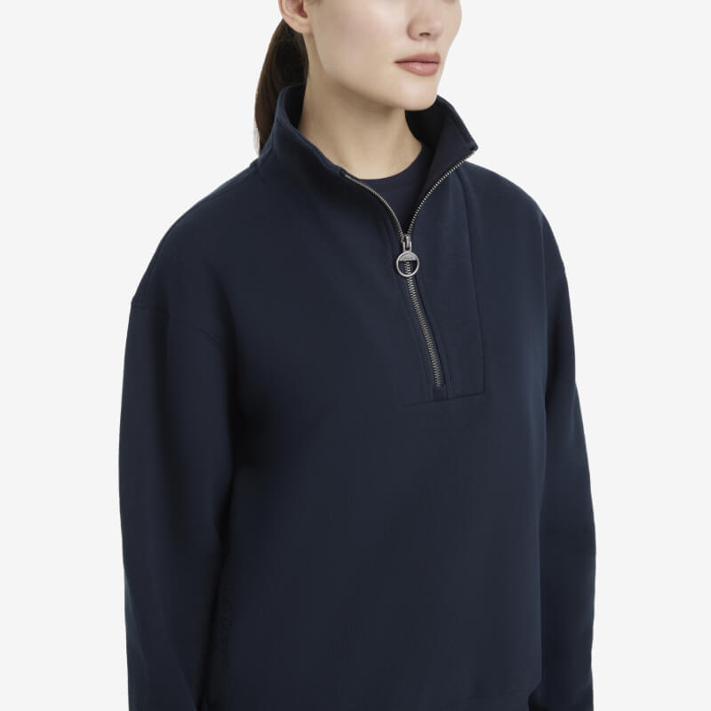 Woman wearing a LeMieux Keira Quarter Neck Sweat Navy with a high collar, facing forward.