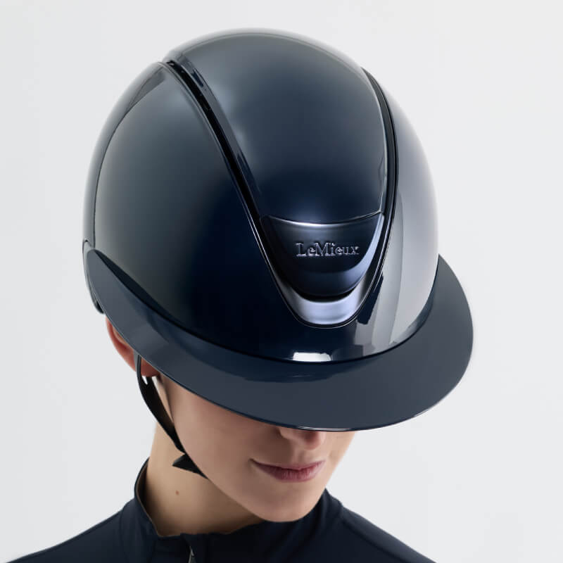 Person wearing a LeMieux Verv® Magnetic Top Panel Gloss Navy helmet, facing downward.