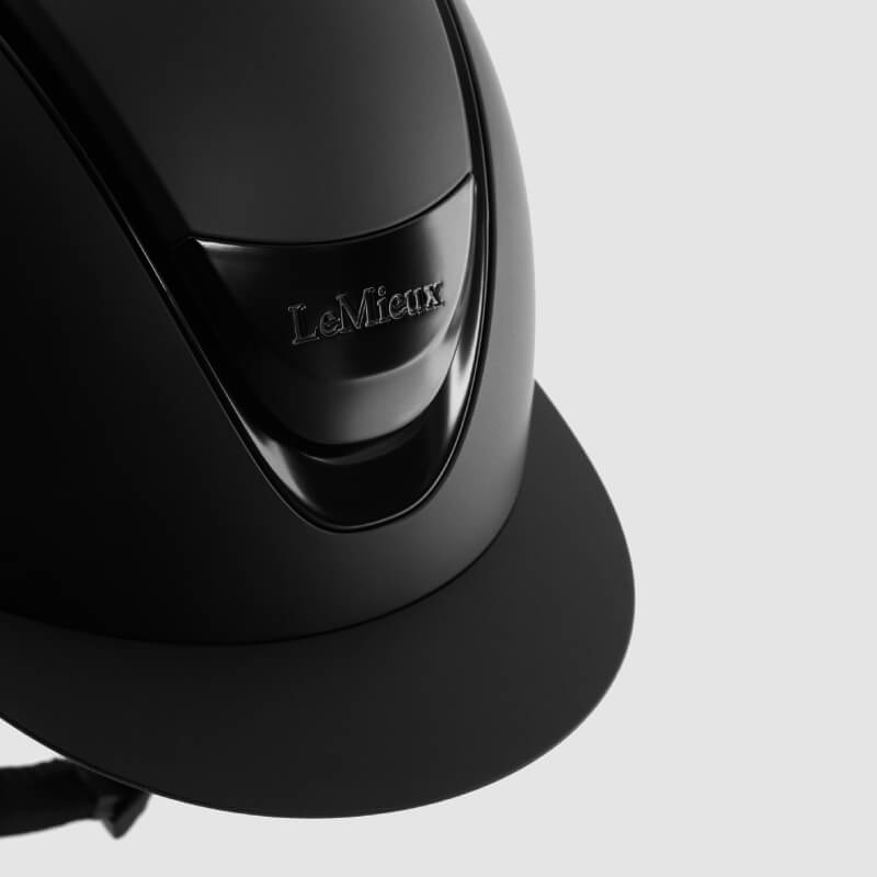 LeMieux Verv® Matte Black helmet offers impact protection with chin strap against a white background.