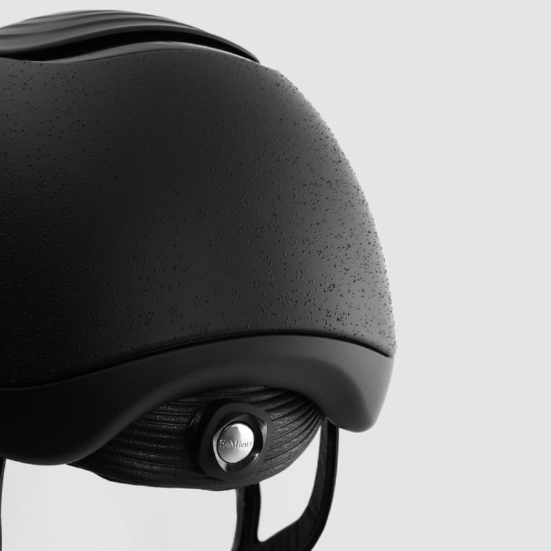 Close-up of a LeMieux Vexa® Skull Helmet Black showing textured finish and metal logo.