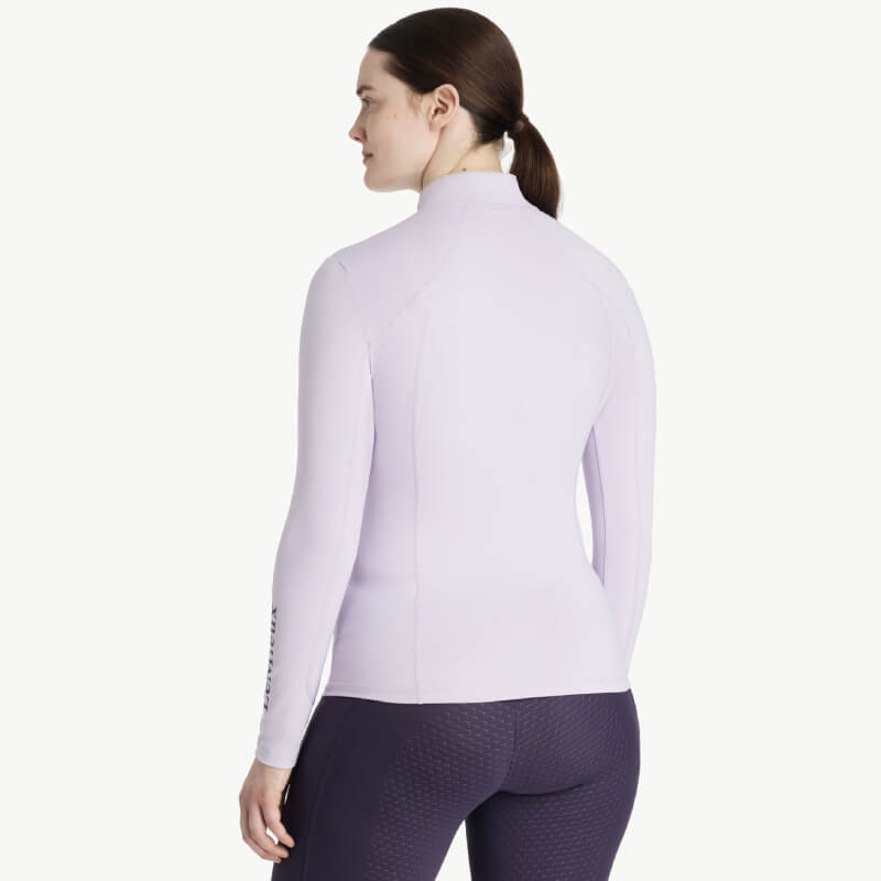 Woman in a fitted LeMieux Classique Baselayer Lilac and dark leggings, facing away.