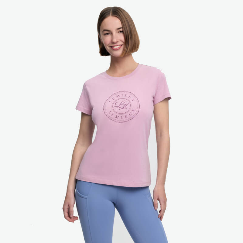 Woman in a LeMieux Classique T-Shirt Fondant and light blue leggings smiles at the camera.