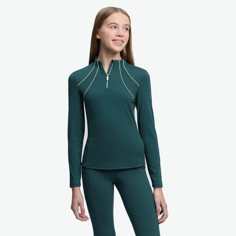 Smiling teen in a LeMieux Young Rider Airflow Baselayer Jungle, teal long-sleeve riding shirt.