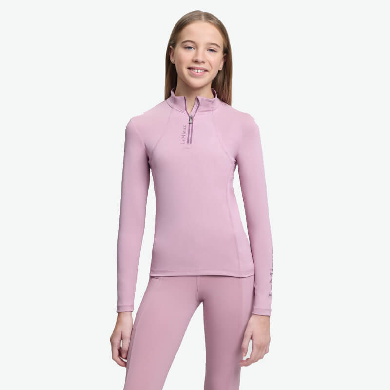 Teen girl in LeMieux Young Rider Classique Baselayer Fondant, smiling in sweat-wicking top.