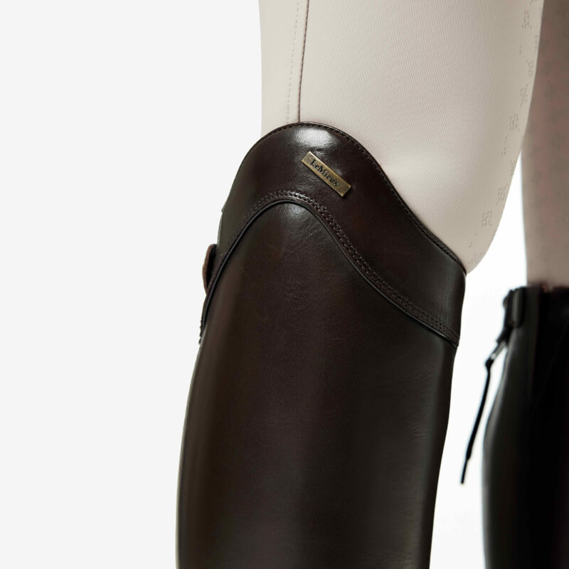 Close-up of LeMieux Field Riding Boot Brown Regular/Full with white pants on lower leg.