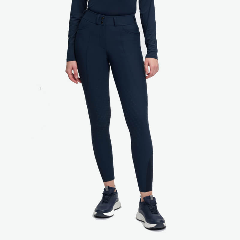 Woman in LeMieux Brilliance Full Seat Breeches Navy and long-sleeve top with sneakers.