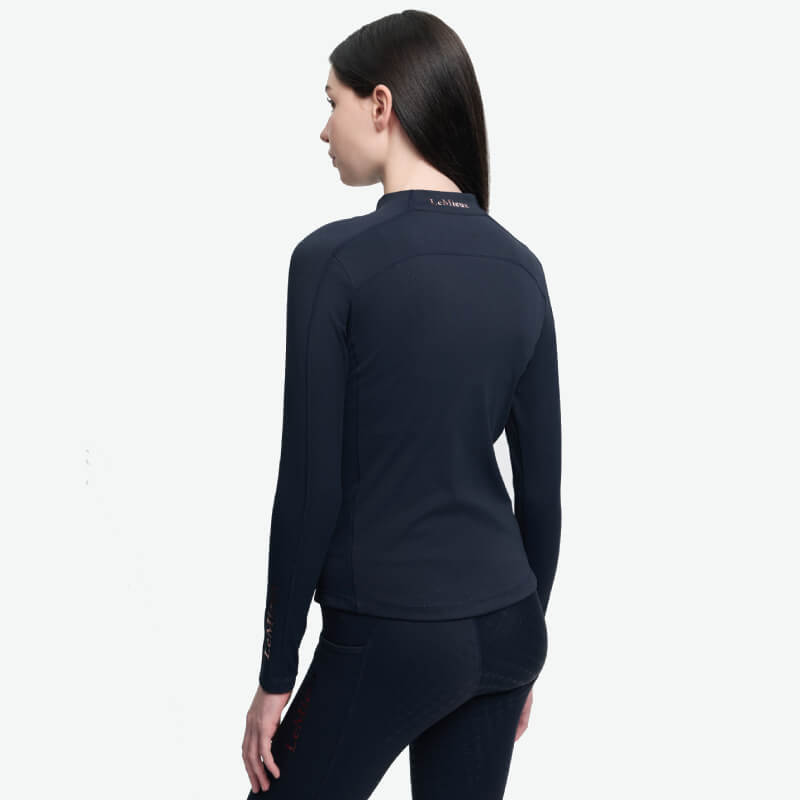 Woman in a fitted LeMieux Young Rider Sparkle Baselayer Navy with UPF30+, seen from behind.