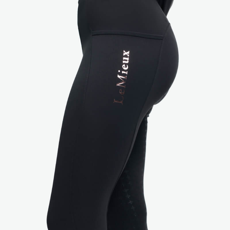 Close-up of LeMieux Young Rider Sparkle Orla Pull On Black tights with logo on the thigh.
