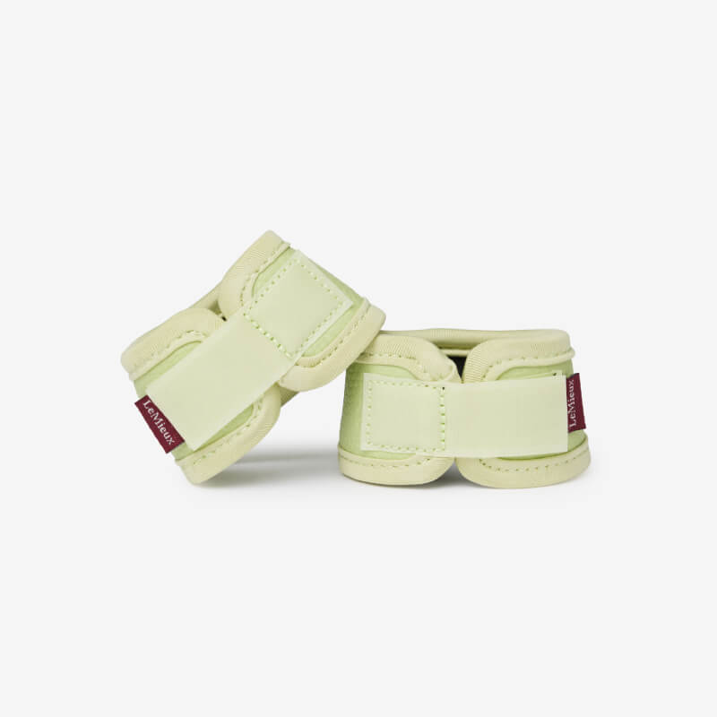 LeMieux Toy Pony Over Reach Boots Macaron in light green with velcro straps on white.