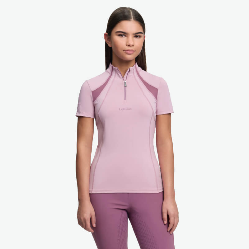 Woman in LeMieux Young Rider Mia Mesh Baselayer Fondant top and leggings on white background.