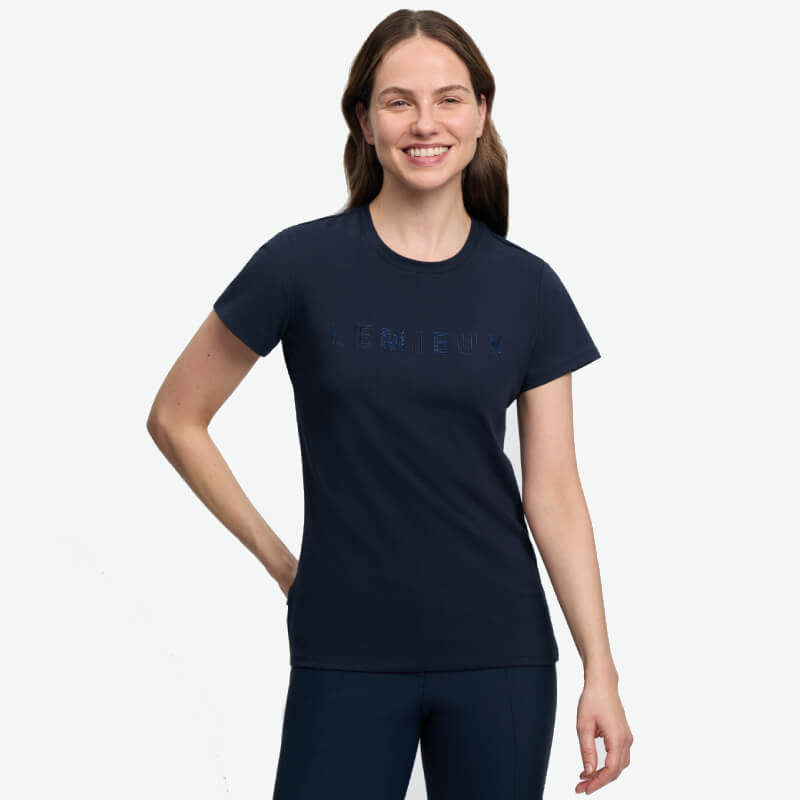 Woman smiling in a LeMieux Brilliance T-Shirt Navy, standing with one hand on her hip.