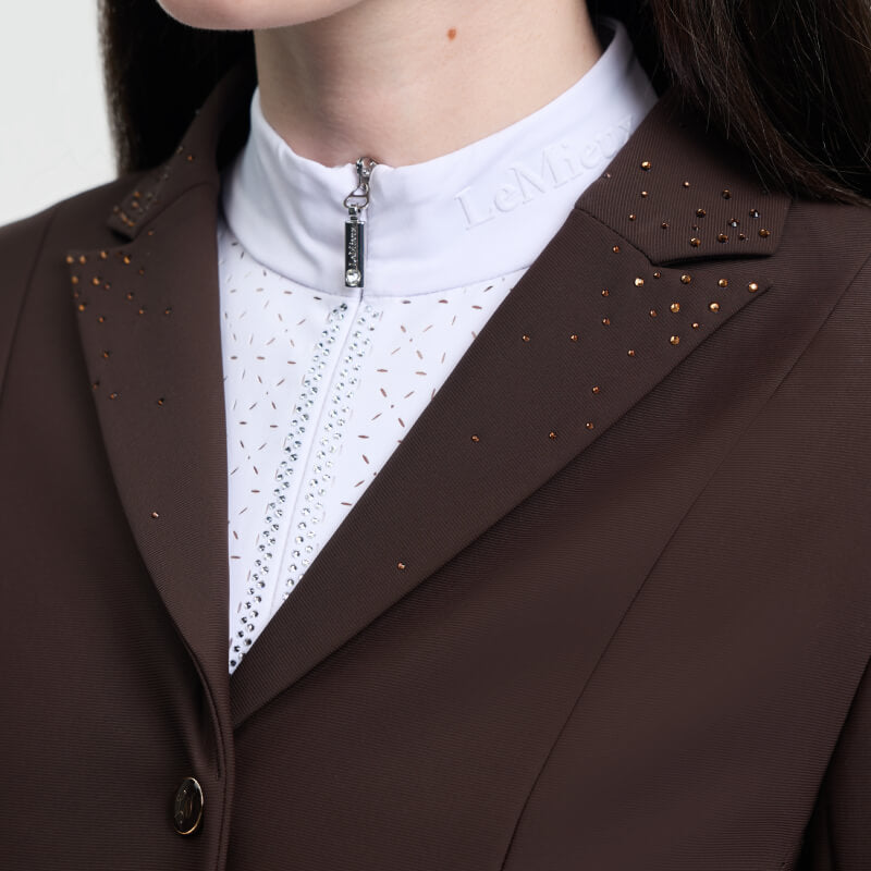 Close-up of a young rider in a LeMieux Brilliance Junior Pro Show Jacket in Espresso.