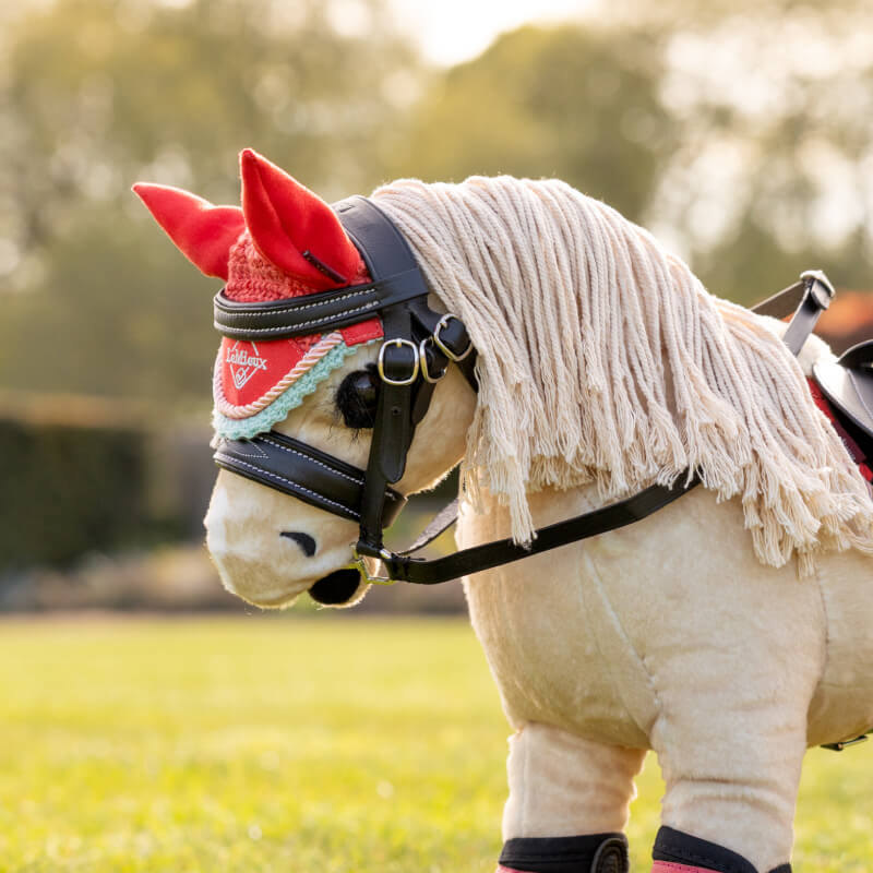 LeMieux Harlow Toy Pony wears a Coral Crush Fly Hood by LeMieux and a decorative bridle.