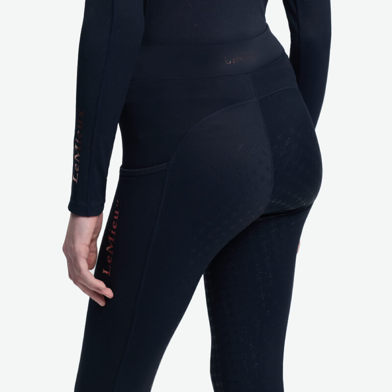 Young rider in LeMieux Young Rider Sparkle Orla Pull On Navy, viewed from behind.