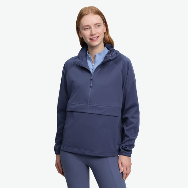 Woman wears the LeMieux Perri Half Zip Waterproof Hoodie Shadow, smiling on a white background.