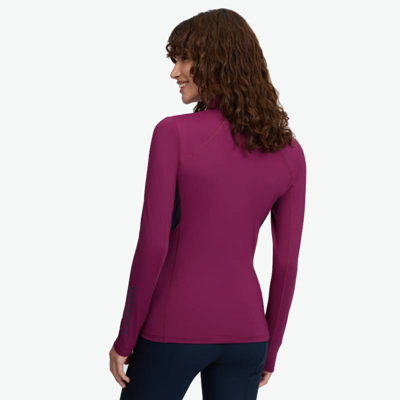 Woman with curly hair in a LeMieux Classique Baselayer Blackberry, facing away from camera.