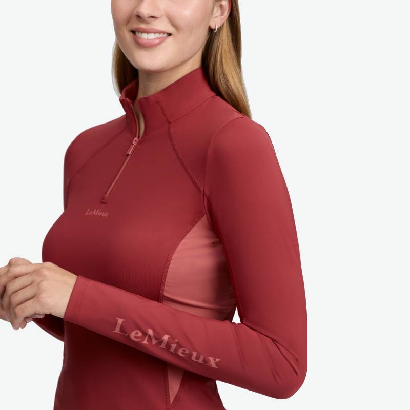 Woman in a LeMieux Classique Baselayer Russet, smiling with hands gently clasped.