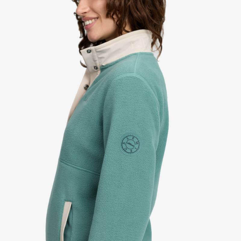 Woman in LeMieux Piper Popper Fleece Aloe with cream collar, smiling, shown from the side.