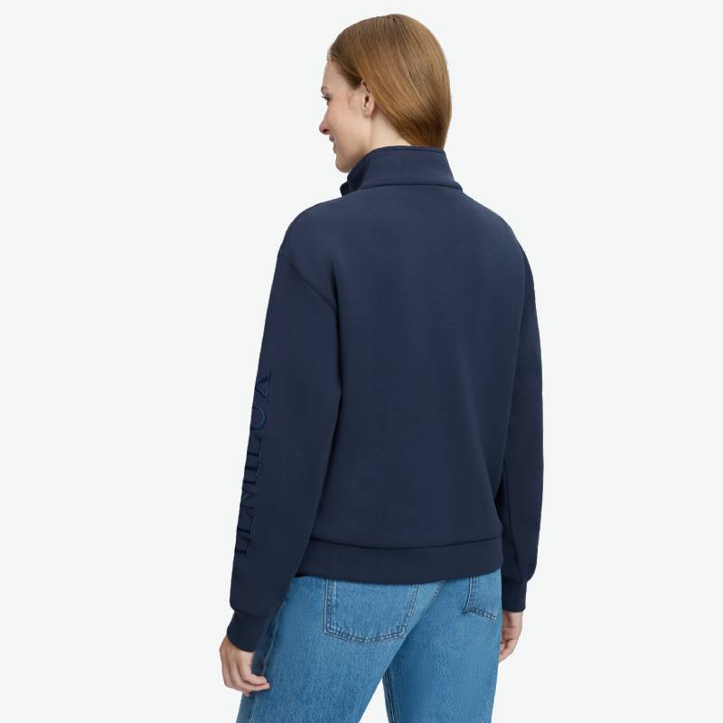 Person wears LeMieux Scarlet Quarter Zip Sweat Navy and blue jeans, back view, plain background.
