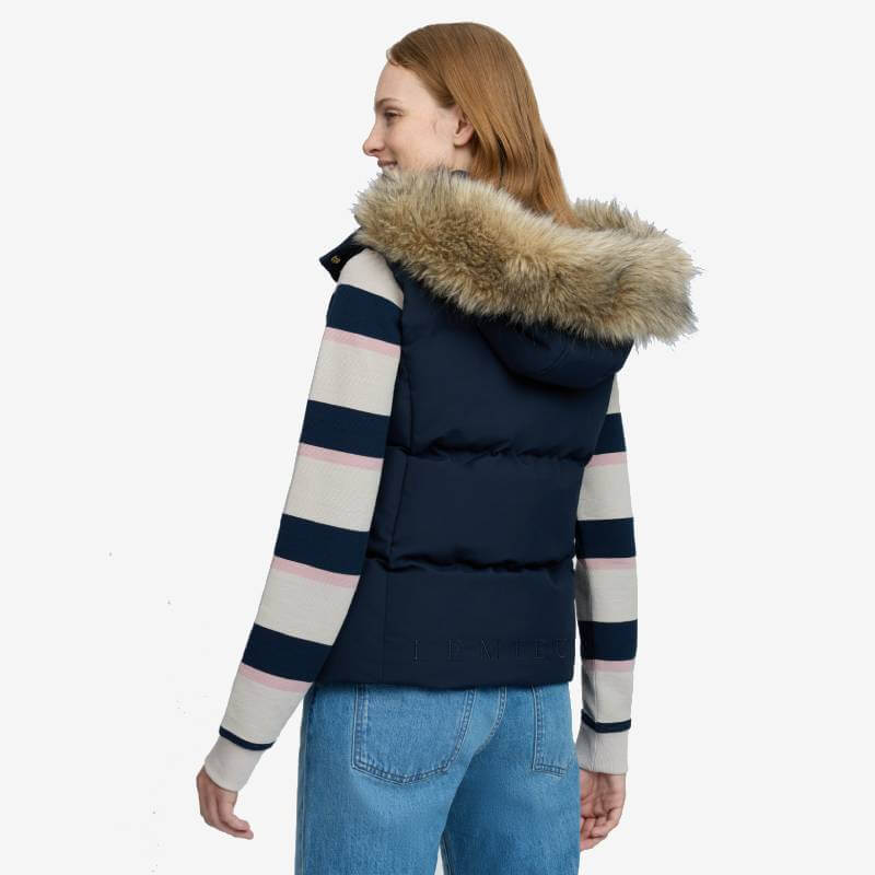 Woman in striped sweater and LeMieux Margot Hooded Gilet Navy, facing away in blue jeans.