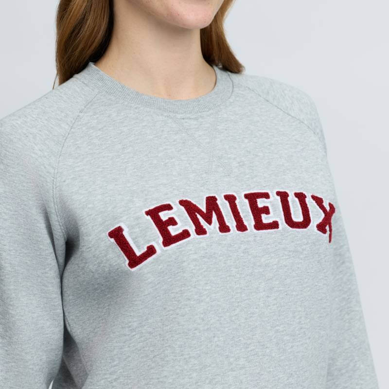 Wearing a LeMieux Vida Varsity Crew Neck Sweat Grey Marl with red LEMIEUX lettering on chest.