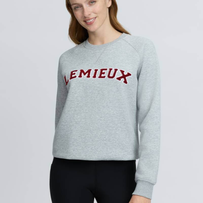 Woman in LeMieux Vida Varsity Crew Neck Sweat Grey Marl, smiling at the camera.