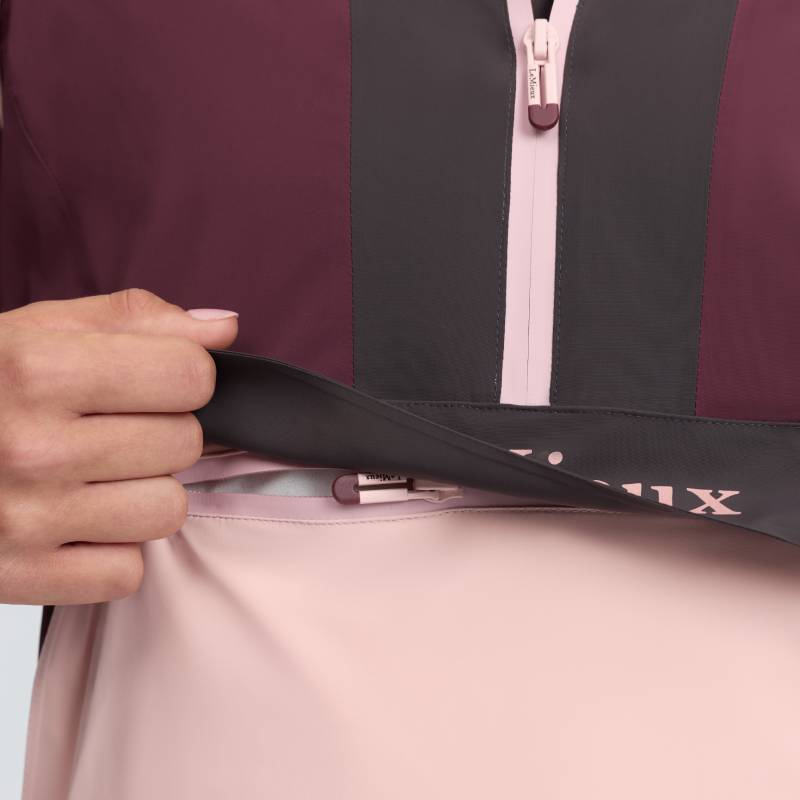 Hand lifts LeMieux Bailey Waterproof Anorak Bramble, revealing a hidden zipper pocket underneath.