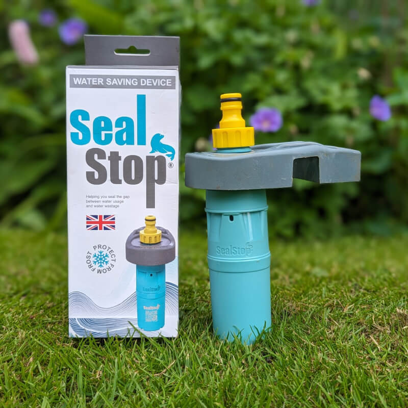 SealStop Valve by SealStop on grass with packaging, garden background softly blurred.