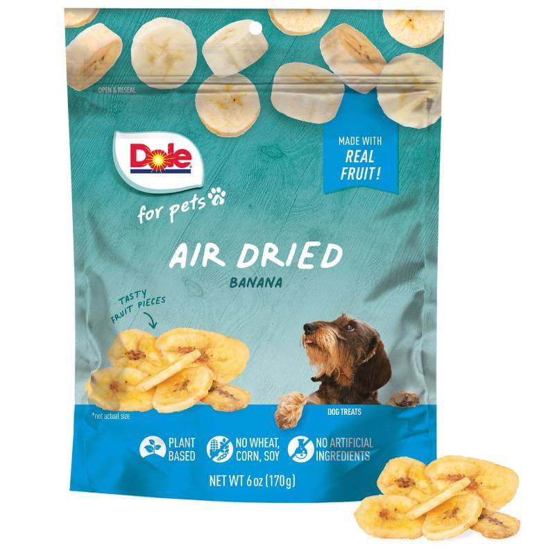 Dole Air Dried Banana Chips 170g bag with plant-based dog snacks and a dog looking up.