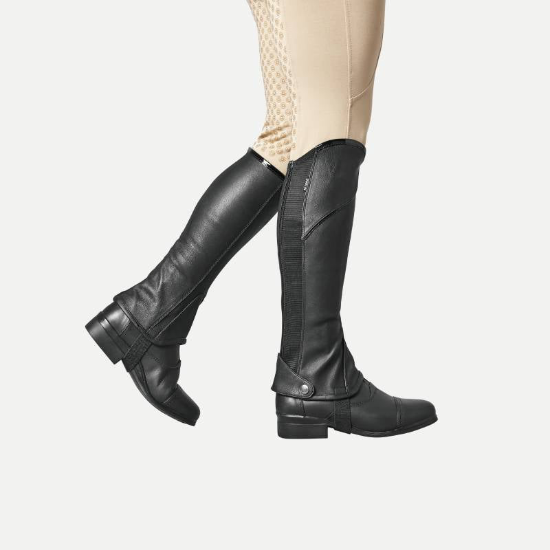 Adult wearing Dublin Stretch Fit Half Chaps in Black/Patent Piping, shown from knees down.