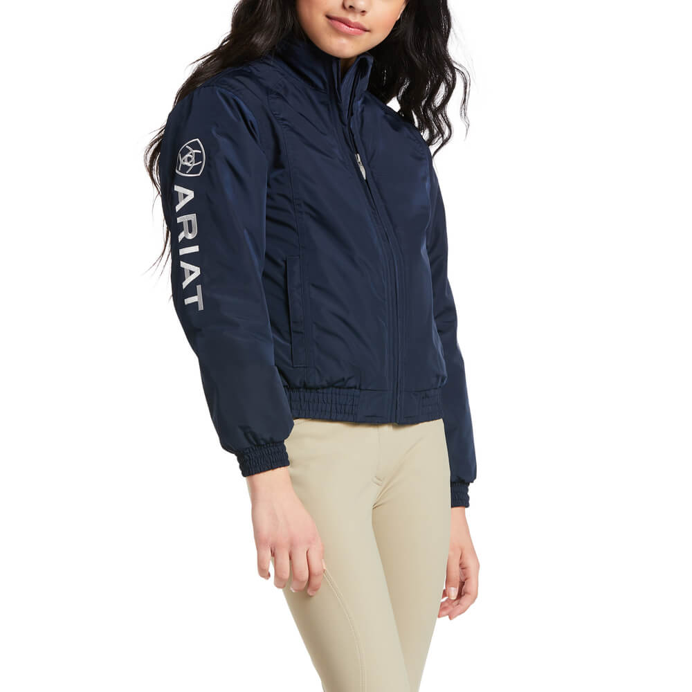 Girl in an Ariat Youth Stable Jacket Navy and beige pants, turned slightly to the side.