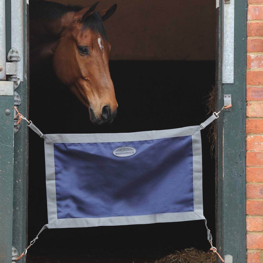 A brown horse stands behind a Weatherbeeta 1200D Stall Guard at the stall entrance.