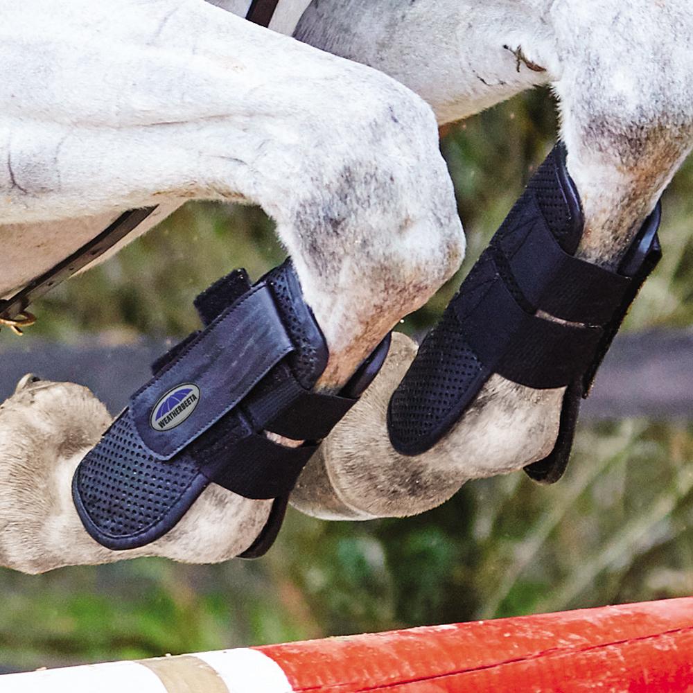 Weatherbeeta Lite Open Front Boots protect horse legs while jumping red and white poles.