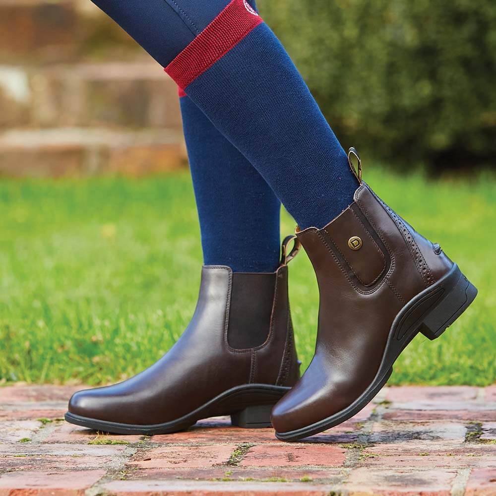Dublin Rapture Jodhpur Child Boot in brown leather with navy riding pants and red-trimmed socks.