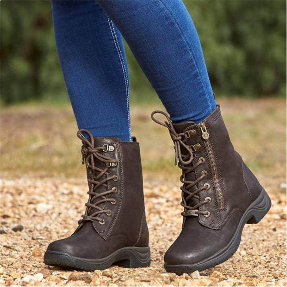 Wearing Dublin Tilly Boots Brown and blue jeans, standing outdoors on a gravel path.