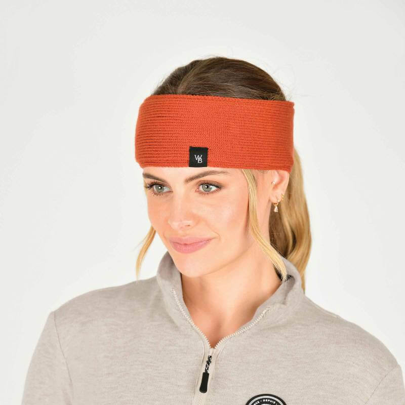 Smiling woman in a Weatherbeeta Fleece Lined Ponytail Headband and light gray zip-up sweater.