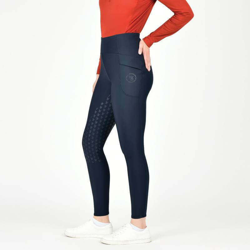 Person in a red top and Weatherbeeta Thermal Riding Tights Sky Captain, with white sneakers.