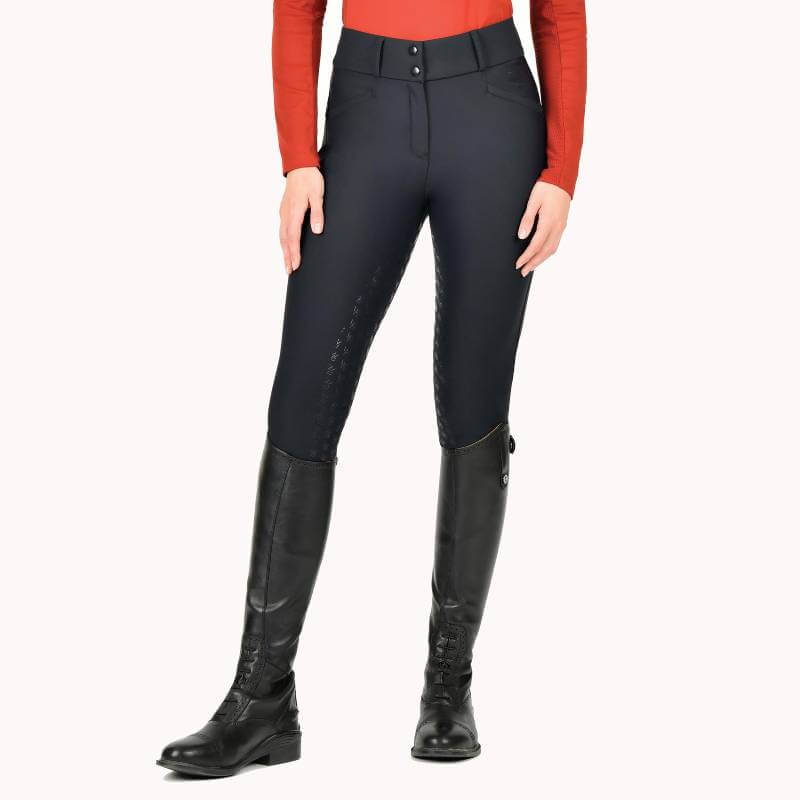 Person wearing Weatherbeeta Thermal Waterproof Breeches Black, tall black boots, and a red top.