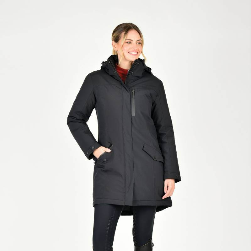 Woman in Weatherbeeta Kyla II Waterproof Jacket Black, smiling with hands in pockets.