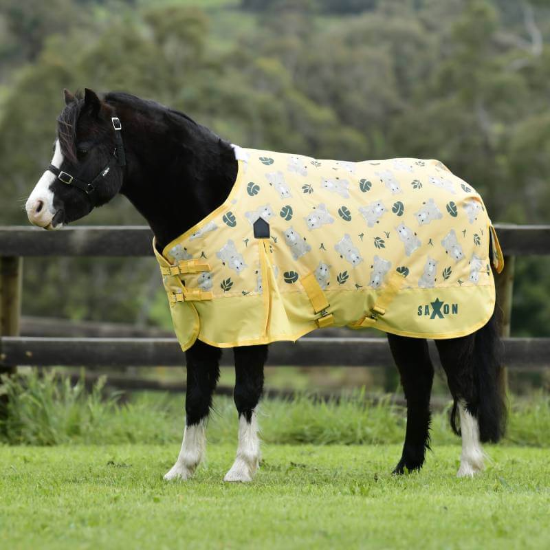 Saxon 600D Pony Standard Neck Medium Rhino Print on a horse stands near a wooden fence.