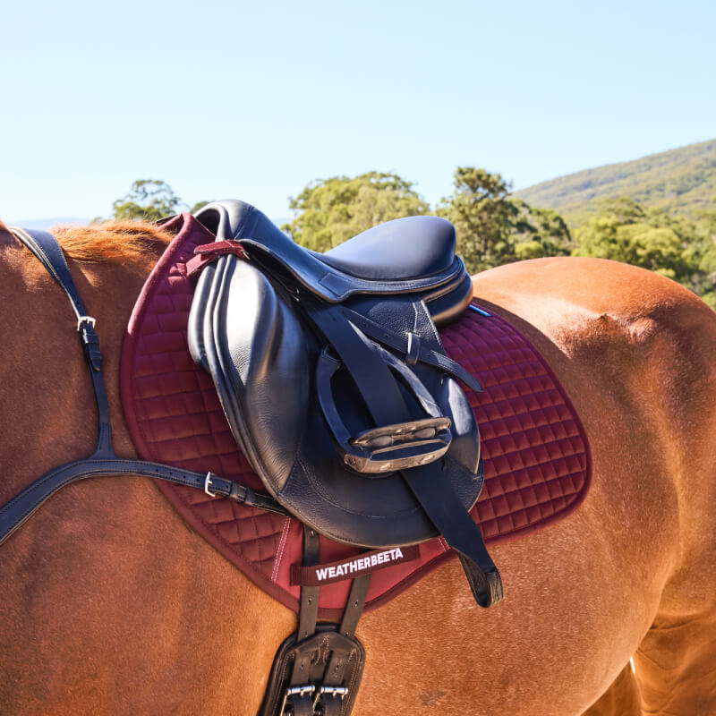 Weatherbeeta Prime Air-Tec Jump Shaped Saddle Pad in Burgundy with logo on white background.