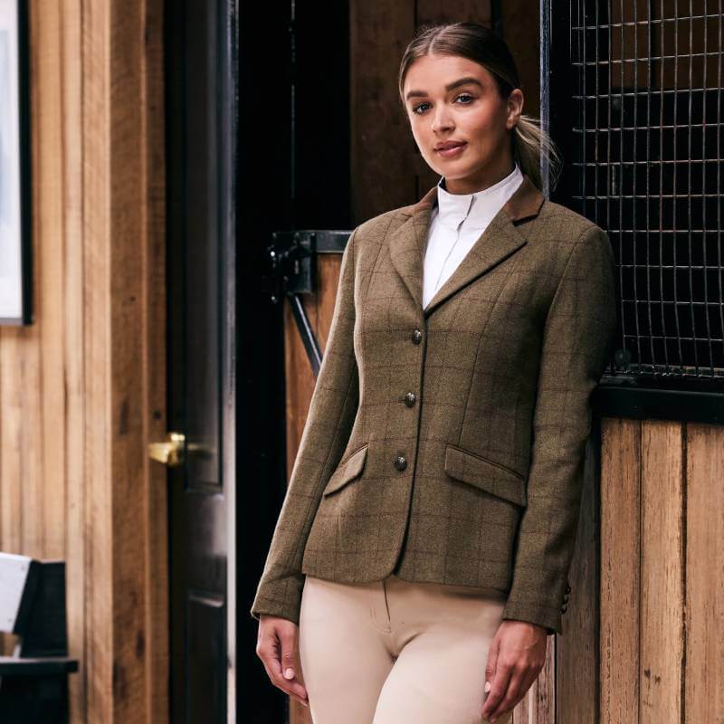 Woman in a Dublin Albany Tweed Suede Collar Tailored Jacket poses by a wooden wall.